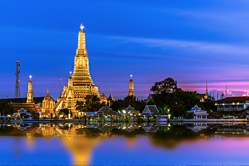 Bangkok at night with illuminated temple and sky.